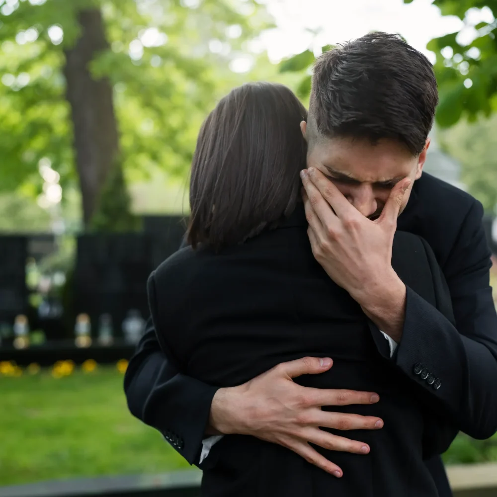 crying-man-woman-embraced-cemetery